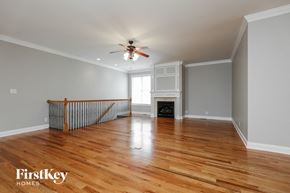 Clarksville house for rent - an empty living room with a ceiling fan and a fireplace