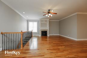 Clarksville house for rent - an empty living room with a ceiling fan and a fireplace