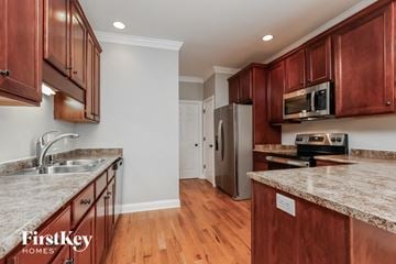 Clarksville house for rent - a kitchen with wood cabinets and granite counter tops and a sink