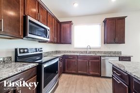 Winter Haven house for rent - a kitchen with wooden cabinets and granite counter tops and a stove and microwave