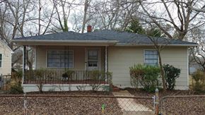 Hueytown house for rent - a yellow house with a porch and a fence