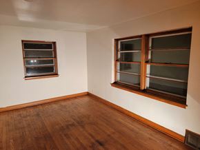 South Milwaukee apartment for rent - an empty room with two windows and a wooden floor