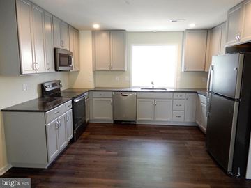 Lansdale apartment for rent - A kitchen with a black fridge and wooden floors.