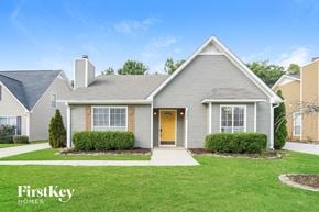 Helena house for rent - a white house with a green lawn and a yellow door
