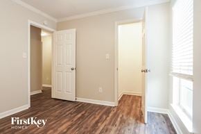 Helena house for rent - a bedroom with wood flooring and a door to a closet
