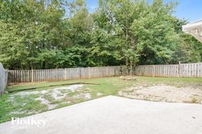Helena house for rent - a backyard with a white fence and a yard with grass and trees