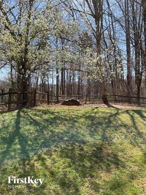 Huntersville house for rent - A grassy field with trees and a fence in the background.