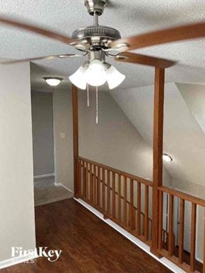Huntersville house for rent - A room with a ceiling fan and a wooden railing.