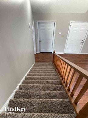 Huntersville house for rent - A staircase with a carpeted runner and wooden balusters.