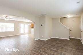 Durham house for rent - A spacious room with wooden flooring and a staircase on the right side.