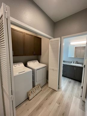 Chico apartment for rent - A laundry sign is on the floor next to a washer and dryer.