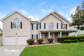 Lawrenceville house for rent - a beige house with black shutters and white garage doors
