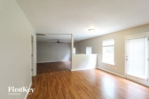 Lawrenceville house for rent - an empty living room with a hard wood floor and a ceiling fan