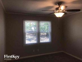 Gastonia house for rent - a bedroom with a ceiling fan and a window