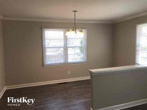 Gastonia house for rent - an empty living room with a window and a chandelier