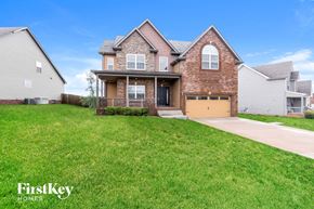 Clarksville house for rent - a house with a yellow garage door in front of a lawn