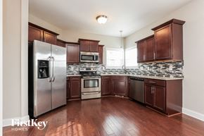 Clarksville house for rent - a kitchen with dark wood cabinets and stainless steel appliances
