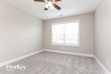 Clarksville house for rent - the living room of a new home with carpet and a ceiling fan