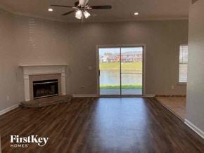 Middleburg house for rent - A spacious room with a fireplace and sliding glass doors leading to a view of a body of water.