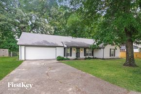 Memphis house for rent - a white house with a driveway and trees
