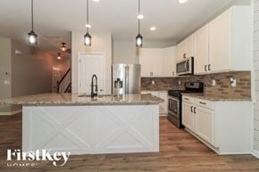 Dallas house for rent - A kitchen with a white island and wooden cabinets.