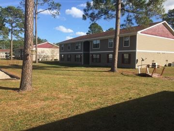 Kingsland apartment for rent - a building with a yard and trees in front of it