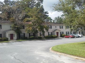 Valdosta apartment for rent - a large white house with cars parked in front of it