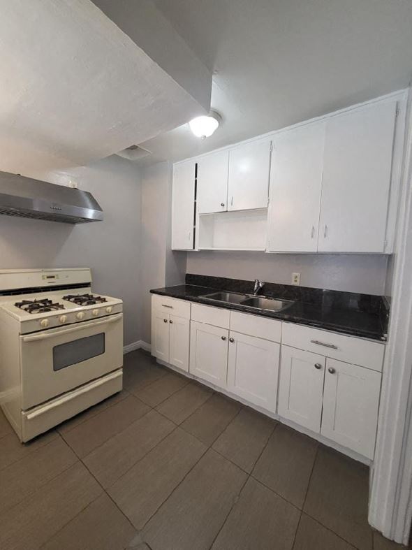Ontario apartment for rent - a kitchen with white cabinets and a stove and a sink