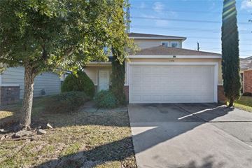 Cypress house for rent - A house with a white garage door is surrounded by a tree and a driveway.