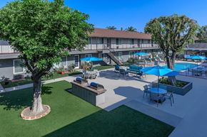 Norwalk apartment for rent - a patio with tables and umbrellas and a swimming pool