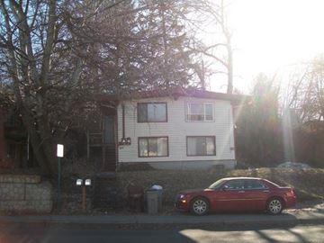 Pullman apartment for rent - A red car is parked in front of a white house.