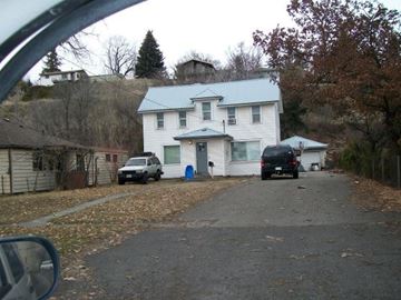Pullman apartment for rent - A white house with a black car parked in front.