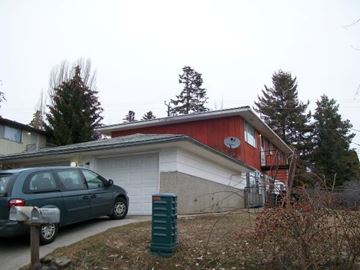 Pullman apartment for rent - A red and white house with a blue car parked in front.