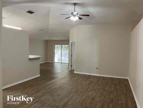 Jacksonville house for rent - A room with a ceiling fan and wooden flooring.