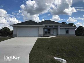 Fort Myers house for rent - a white house with a driveway and grass