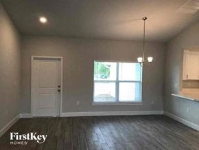 Fort Myers house for rent - an empty living room with a white door and a window