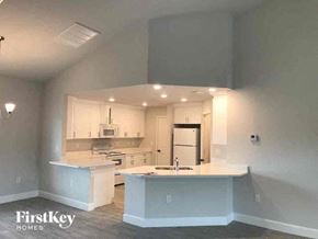 Fort Myers house for rent - an empty kitchen with white cabinets and a sink