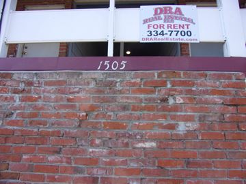 Pullman apartment for rent - a brick wall in front of a building with a sign on it