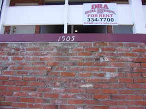 Pullman apartment for rent - a brick wall in front of a building with a sign on it