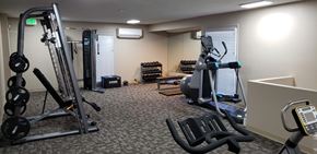 Denver apartment for rent - a gym with exercise equipment in a room with a couch