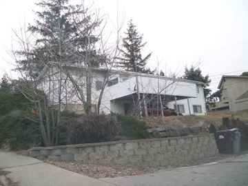 Pullman apartment for rent - A house with a white exterior and a stone wall in front.