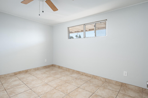 El Cajon apartment for rent - A room with a ceiling fan and a window with a view of trees.