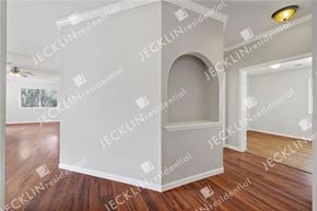 Leander house for rent - A room with wooden floors and white walls, with a large arched doorway on the right.