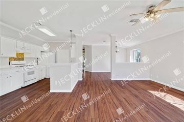 Leander house for rent - A spacious kitchen with white cabinets and a wooden floor.