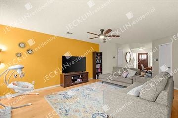 Pflugerville house for rent - A living room with a grey couch and a television on a wooden stand.