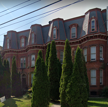 Reading apartment for rent - a large brick building with trees in front of it