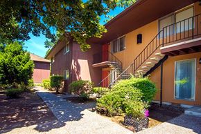 Portland apartment for rent - an apartment building with stairs and bushes in front of it