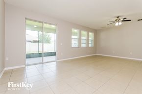 Orlando house for rent - A spacious room with a ceiling fan and sliding glass doors leading to a backyard.