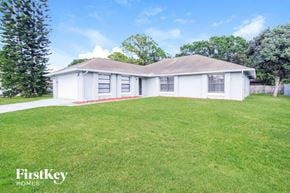 Palm Bay house for rent - A white house with a red stripe on the lawn.