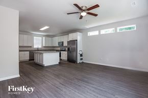 Gastonia house for rent - an empty living room and kitchen with a ceiling fan